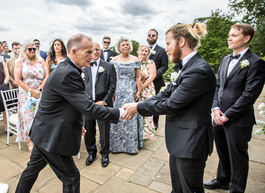 father, greets, groom, shake hands.