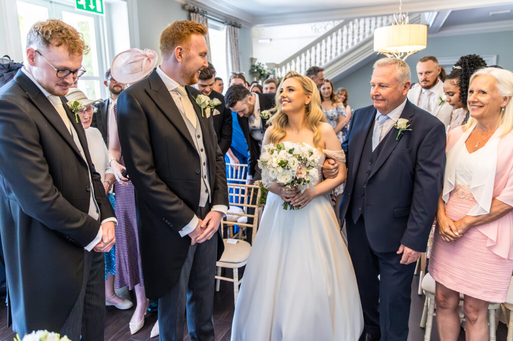 Bride looking at groom for first time during wedding ceremony in Willow Room at Morden Hall