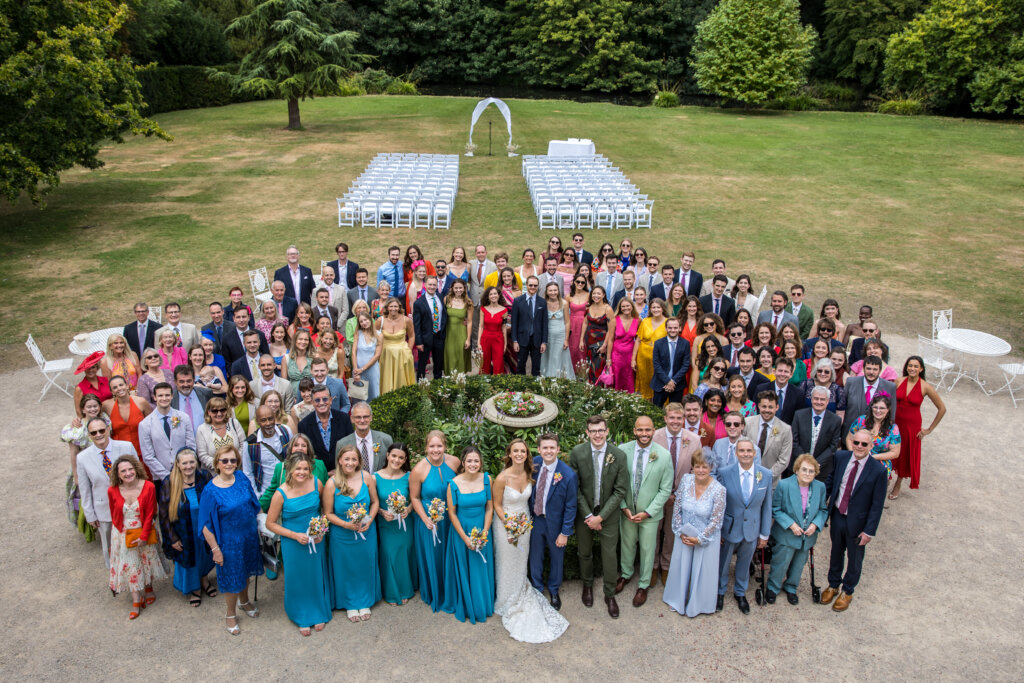 High angle photo of all wedding guests gathered on the Morden Hall lawn taken from first floor balcony